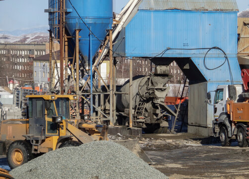 kazakhstan, Ust-Kamenogorsk, february 15, 2021: Construction site. Trucks and wheel loader. Concrete, cement plant. New residentential area