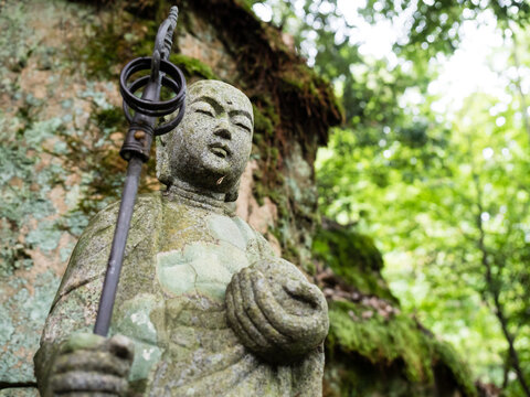 Stone Jizo statue on a mountain path leading to Fukuoji temple - Hiroshima prefecture, Japan