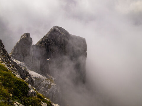 Foggy Day In The Mountains. Mountain Peak Peeks Through The Clouds