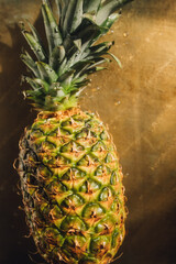 whole ripe pineapple on golden background	