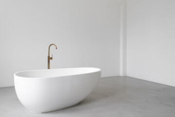 Obraz na płótnie Canvas White bathtub standing in modern and minimalistic bathroom