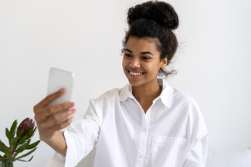 Smiling african american girl looking at smartphone