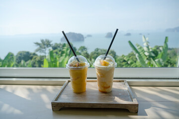 Mango yogurt smoothie set up on wooden plate