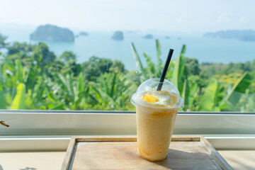 Mango yogurt smoothie set up on wooden plate