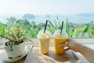 Mango yogurt smoothie set up on wooden plate