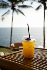 Orange juice on table seaside during sunset sky.