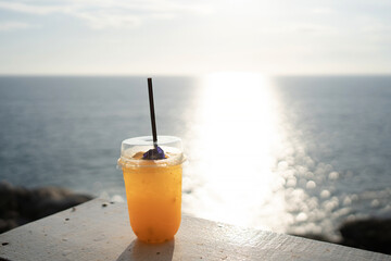 Orange juice on table seaside during sunset sky.