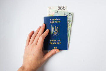 Woman's hand holds Ukrainian biometric passport with payment from Polish state to refugees from...