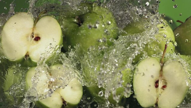 Slow Motion Shot of Green Apple Water Splashing through Apple Slices