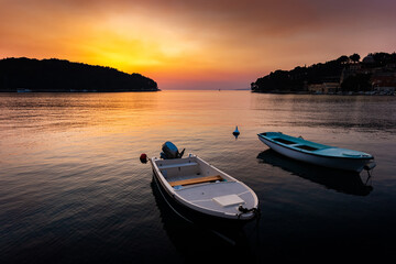Fototapeta na wymiar Fishing boats in a sea, near coast. Sunset time.