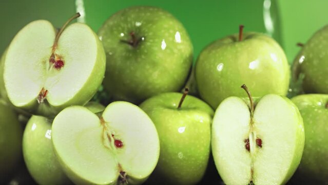 Slow Motion Shot of Green Apple Juice Splashing through Apple Slices