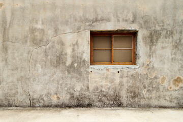 A wooden framed window on a cement wall