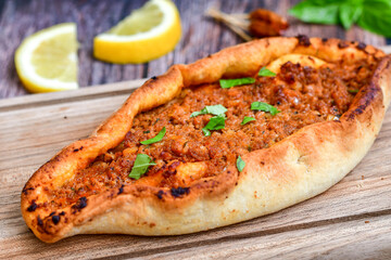  Traditional Turkish cuisine. Baked Pide dish with  cheese and  herbs on  wooden background.  Turkish pizza pide