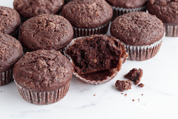 Pile of chocolate muffins on a white background