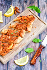 Traditional Turkish cuisine. Baked Pide dish with minced  beef, tomatoes and  herbs on  wooden background.  Turkish pizza pide