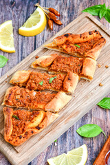  Traditional Turkish cuisine. Baked Pide dish with minced  beef, tomatoes and  herbs on  wooden background.  Turkish pizza pide