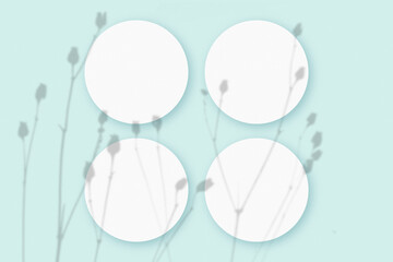 Mockup with vegetable shadows superimposed on 4 round sheets of textured white paper on a blue table background