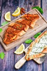  Traditional Turkish cuisine. Baked Pide dish with minced  beef, tomatoes and cheese on  wooden background.  Turkish pizza pide