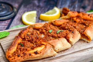  Traditional Turkish cuisine. Baked Pide dish with minced  beef, tomatoes and cheese on  wooden background.  Turkish pizza pide