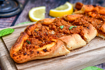  Traditional Turkish cuisine. Baked Pide dish with minced  beef, tomatoes and cheese on  wooden background.  Turkish pizza pide