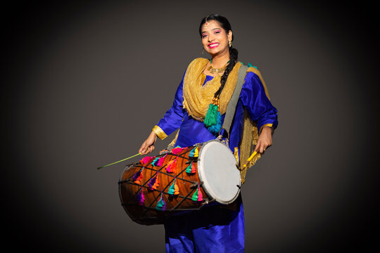 Portrait of Sikh woman playing drum during Baisakhi celebration