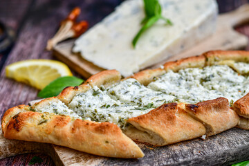  Traditional Turkish cuisine. Baked Pide dish with minced  beef, tomatoes and cheese on  wooden background.  Turkish pizza pide