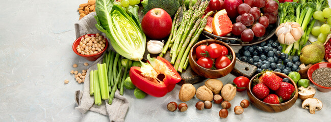 Delicious raw fruits and vegetables on light background.