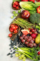 Delicious raw fruits and vegetables on light background.
