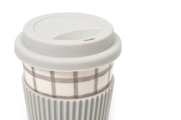 Checkered ceramic cup with rubber lid, shot against a white background.