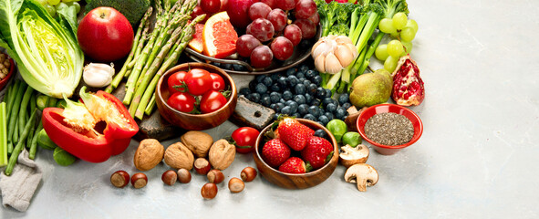 Delicious raw fruits and vegetables on light background.