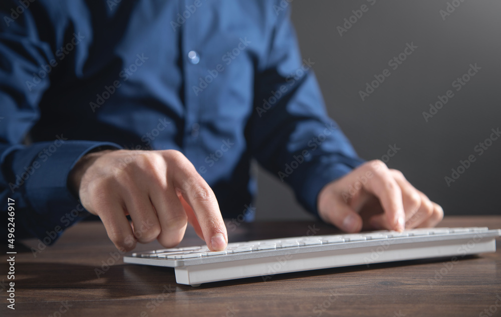 Wall mural male hands typing on computer keyboard.