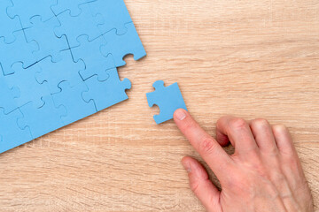 Hand completing the puzzle with the last piece