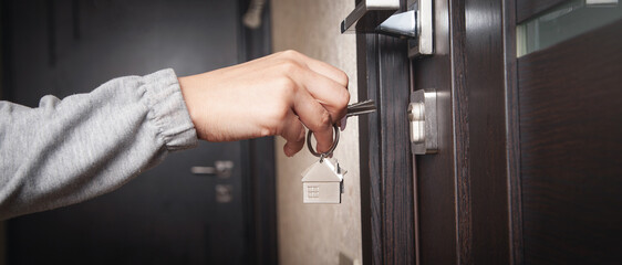 Naklejka premium Woman hand holding house key at home.