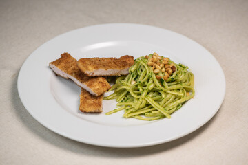Turkey cutlet and Green spinach spaghetti with cheese and tomato on wooden table. High quality photo