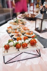 Canape snacks on the stands on the banquet table