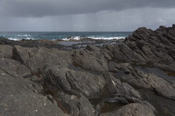 Fototapeta na wymiar Gran Canaria, north coast, rockpools around Puertillo de Banaderos area protected from the ocean waves by volcanic rock barrier 