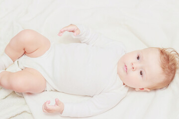 Happy child on the white blanket, blurred background