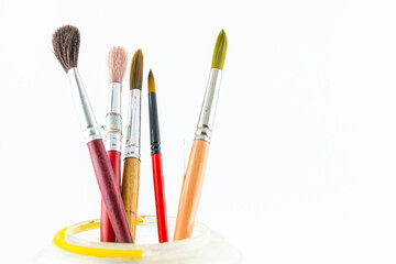 Close focus on group of paintbrushes on white background.
