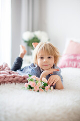 Fototapeta premium Cute toddler blond child with shirt, sitting on the bed with Valentine decoration