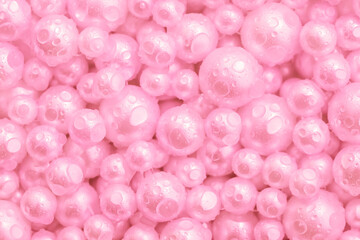 Beautiful background pink pearl pearls, top view. Abstract texture for festive backgrounds. Shiny surface of Christmas decorations. Gems close-up. Multicolored bright background.