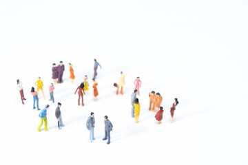Group of miniature people meeting on white background. top view.