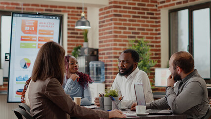 Business people arriving together in meeting office, talking about project planning and startegy. Colleagues working on company growth and development, using data analysis and statistics.
