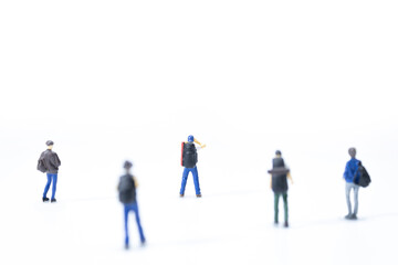 Group of miniature traveler standing on white background.