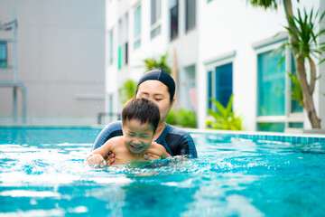 Mom with preschool sun swim in condominium swimming pool outdoor activity