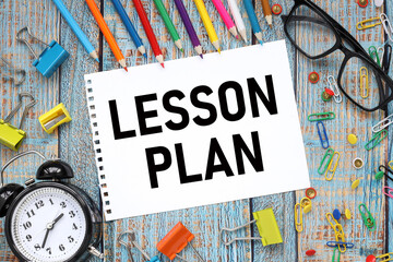 Lesson Planning text on paper from a notepad on a blue wooden background near orange blue and other...