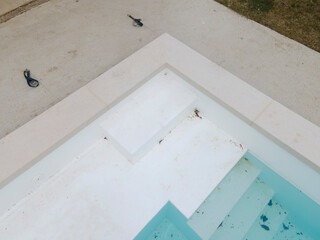 Aerial view of pool construction site with stone border in a garden all not finished yet