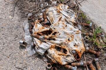 DEs boulons et des ecrous enciens et rouillés dans un chiffon sur le sol