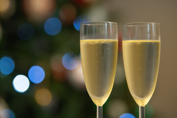 Champagne glasses over holiday bokeh blinking background, glasses with sparkling wine, celebration, party. High quality 4k footage