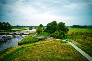 Drone view of the river Vecht, green grass, trees, beautiful blue sky and cycle path through the Vecht valley. Bridge and weir in the river. Dalfsen Netherlands