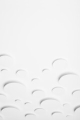 Abstract geometric texture of flying white paper ovals in shining light with soft shadows as mess pattern, top view, border, copy space, vertical. Delicate clean airy calm background in minimal style.